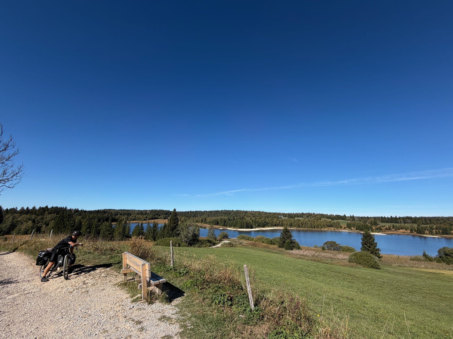Bikepacker rust uit boven het Lac des Mortes in de Jura