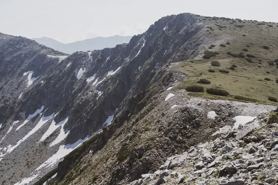 Rotsige bergkam met sneeuwresten in het Rila-gebergte