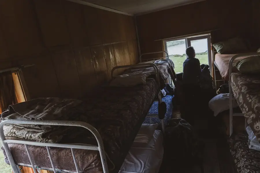 Eenvoudige slaapzaal met ijzeren stapelbedden in de refuge